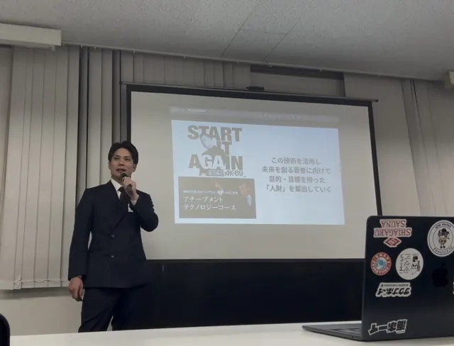 スクリーンの前で発表